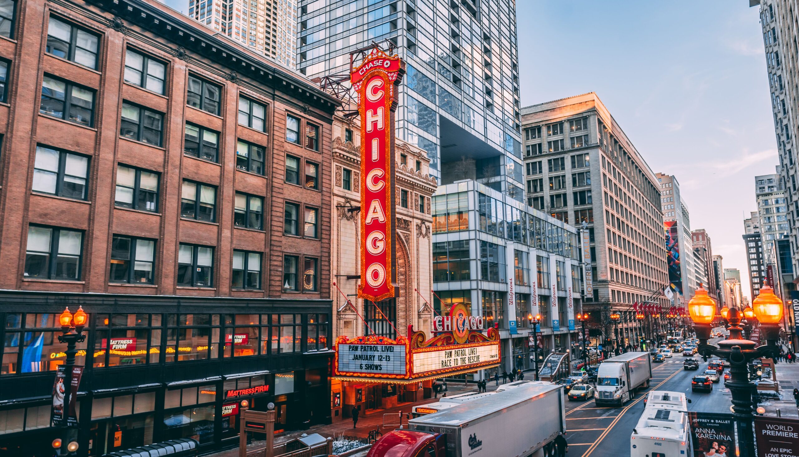 Chicago Theater sign in downtown Chicago with busy street traffic and historic buildings at sunset