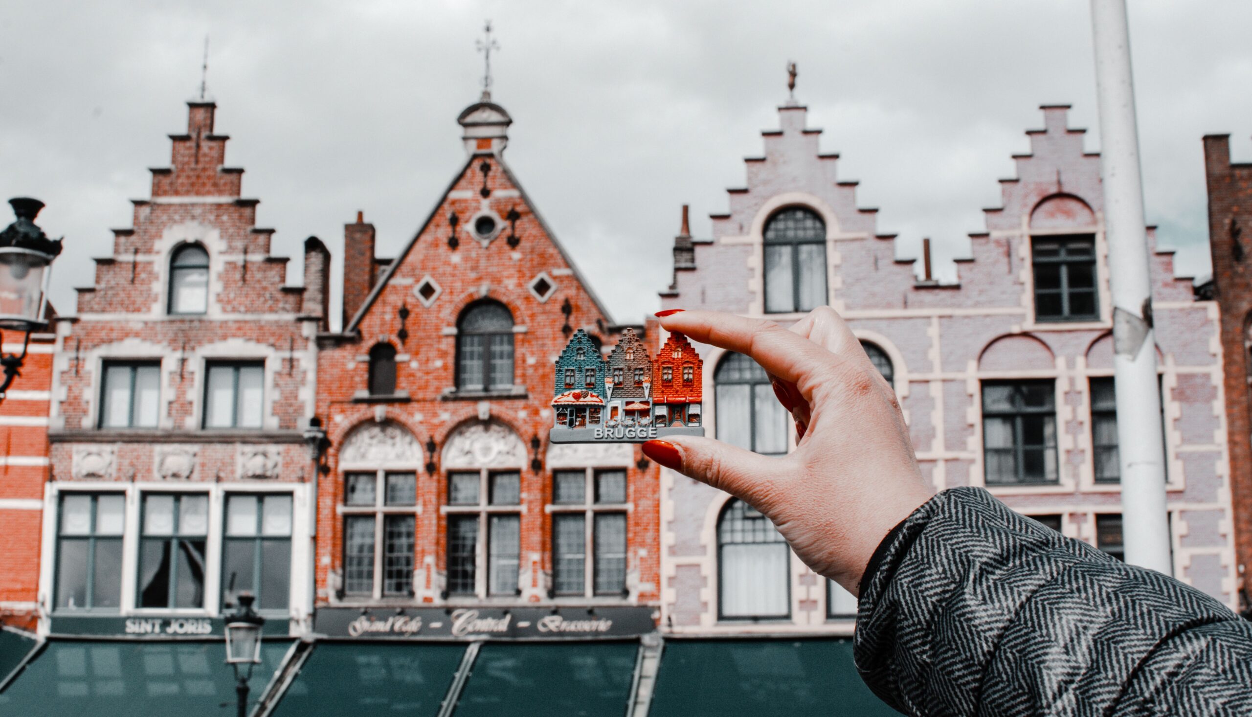 Real estate valuation illustration with a hand holding a small house in front of bigger houses