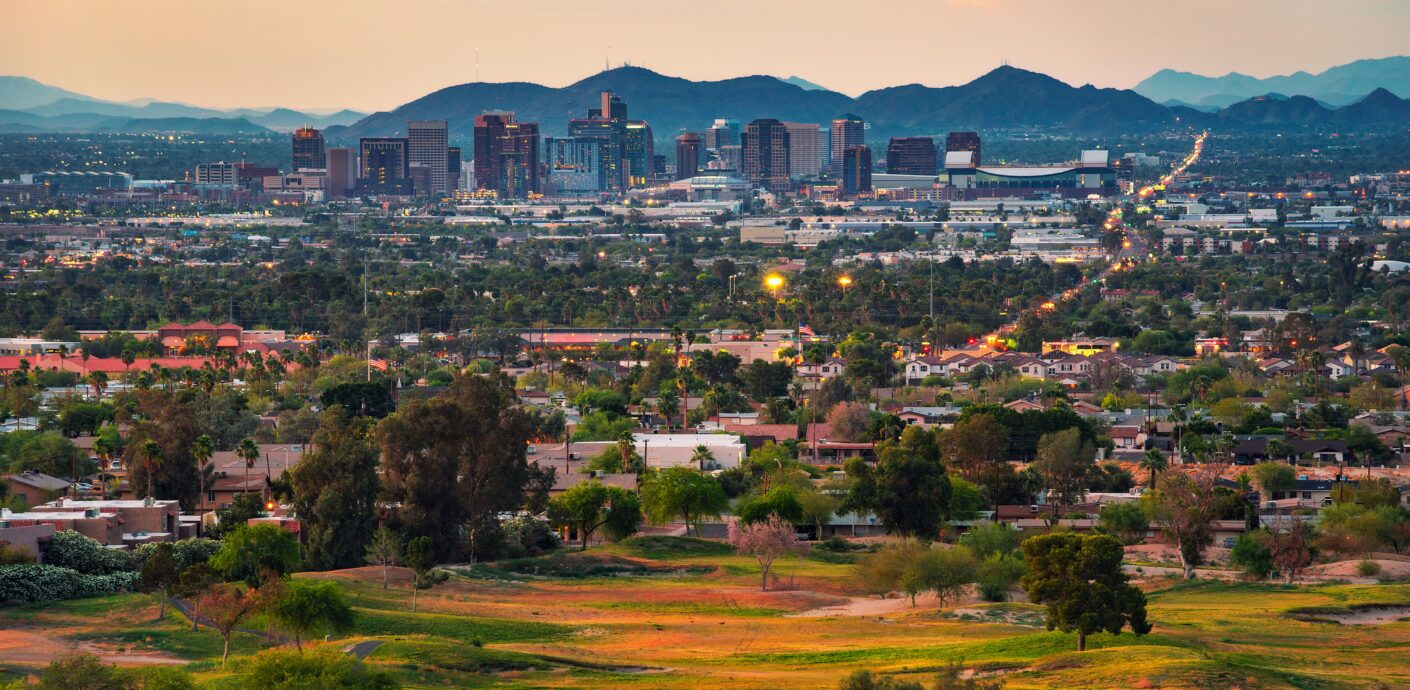 Phoenix Property Appraisal skyline at sunset with downtown buildings and desert mountains in view.