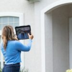 ppraiser photographing a house from the sidewalk during a drive-by appraisal